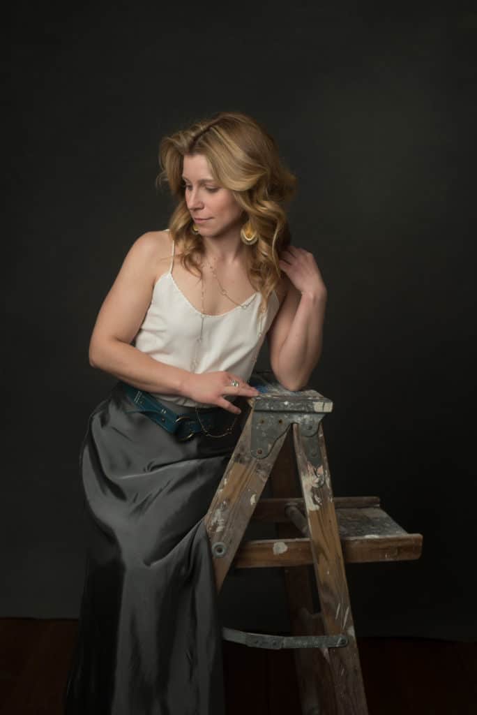 blonde model wearing a white cami top and grey skirt with blue belt. Vanity Fair style fine art portraits in South Jersey