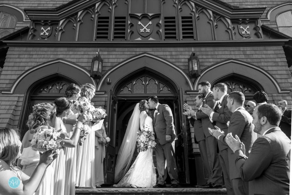 black white photo of bride and groom outside the church