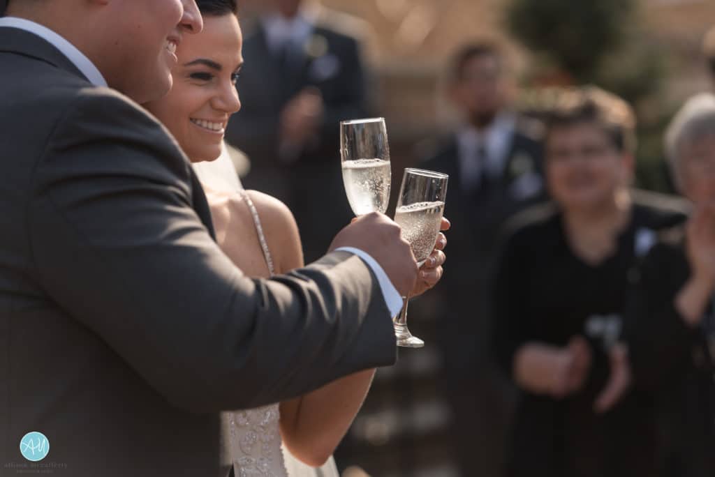 Bride and groom toast champagne outside the church