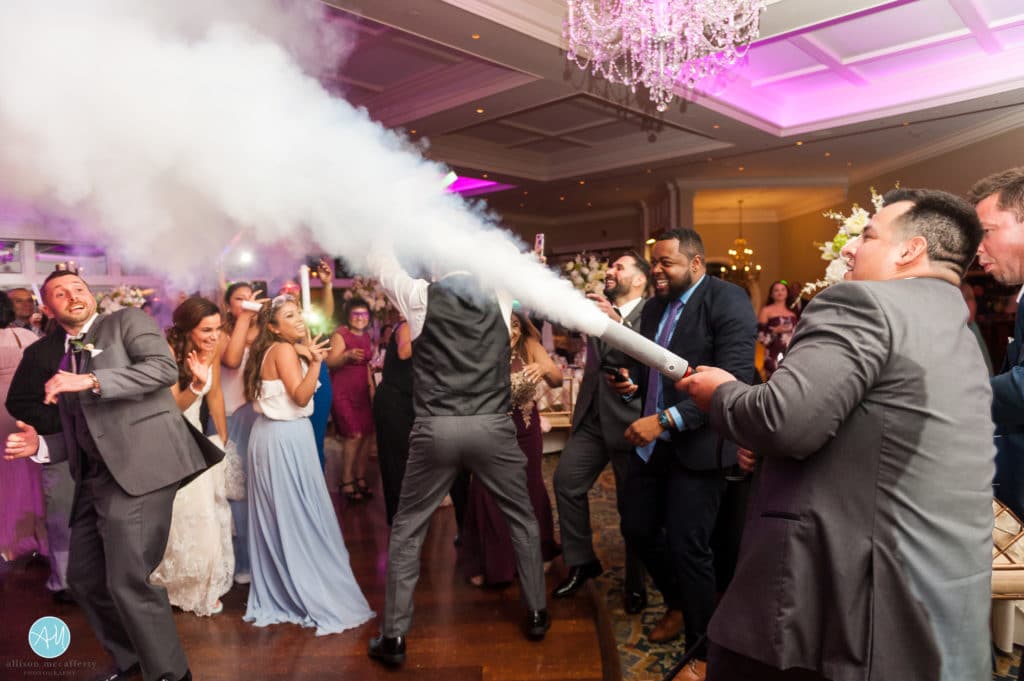Groom spraying CO2 machine at wedding reception