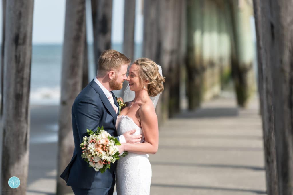 bride and groom under fishing pier avalon nj