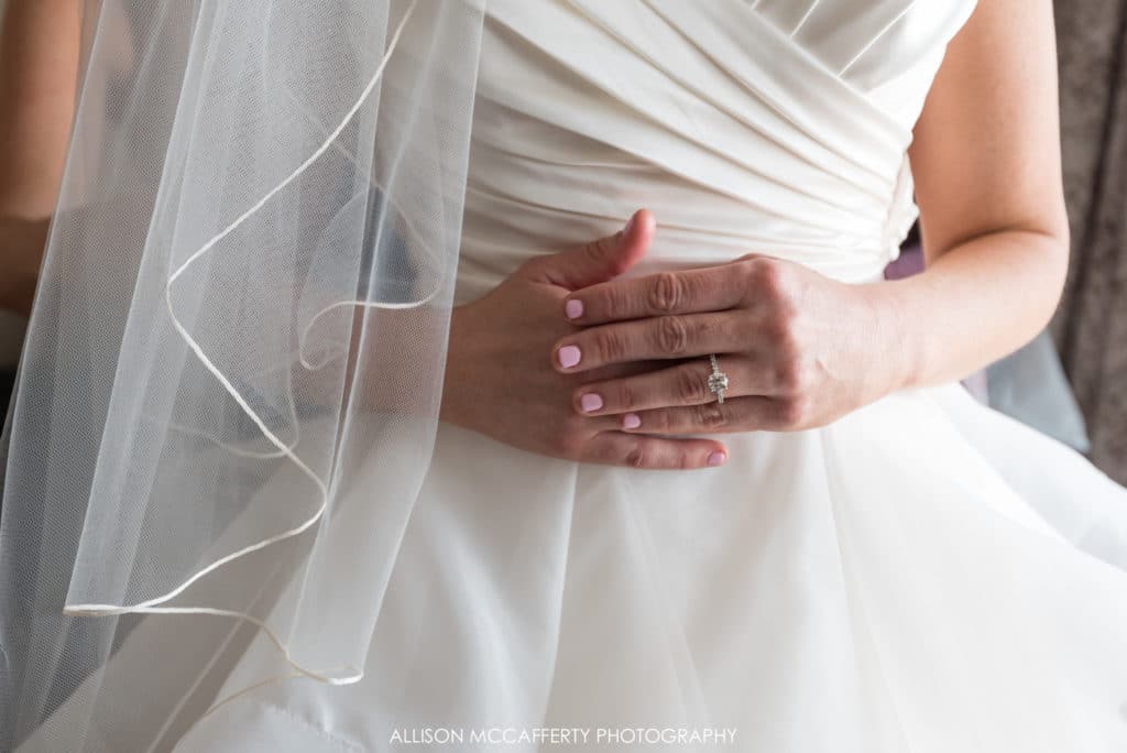 Bride's hands in front of wedding dress