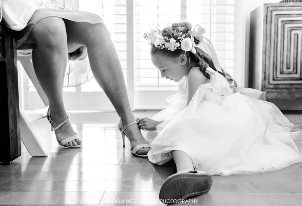 Flower girl helping her Mom put shoes on