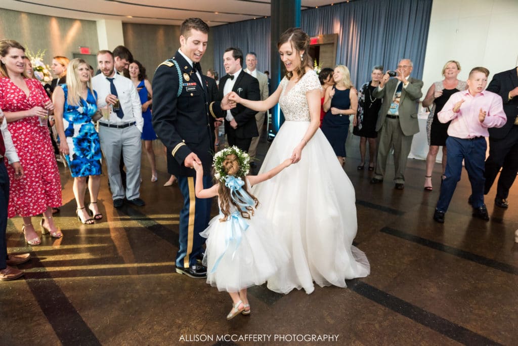 bride, groom and flower girl on the dance floor