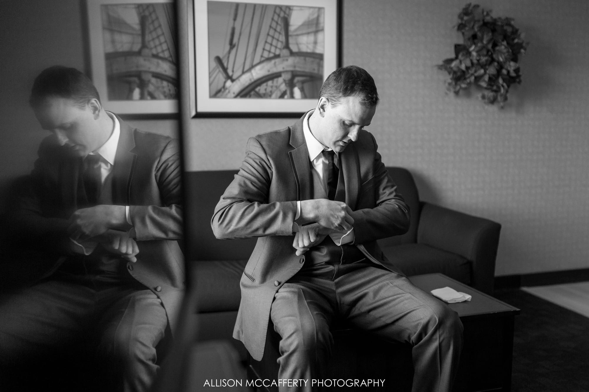 Groom getting ready in hotel room with a reflection