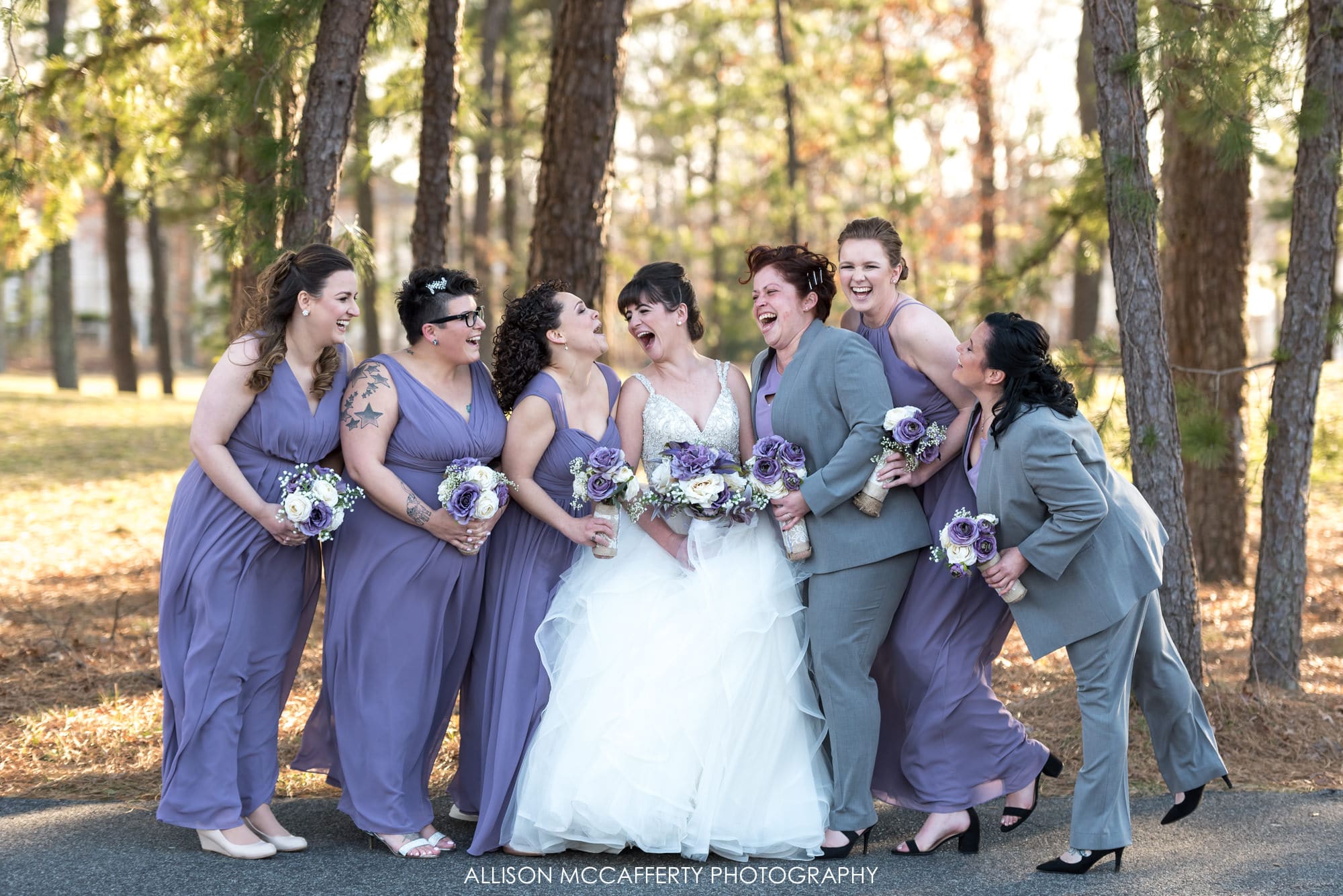 Bridemaids in purple dresses laughing with the bride