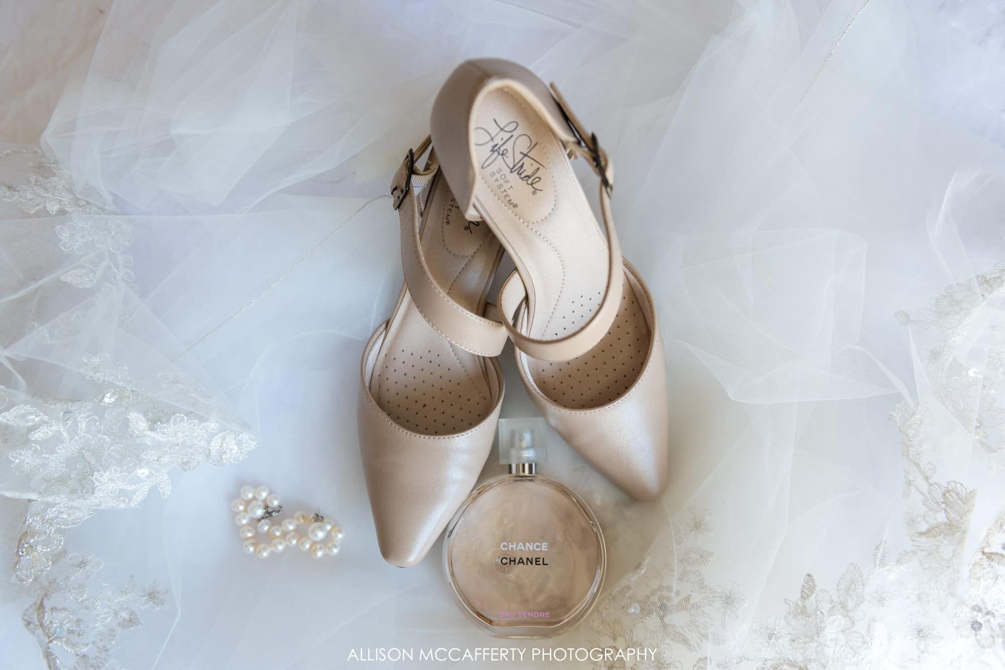 Wedding details, shoes, jewelry and perfume on a lace veil