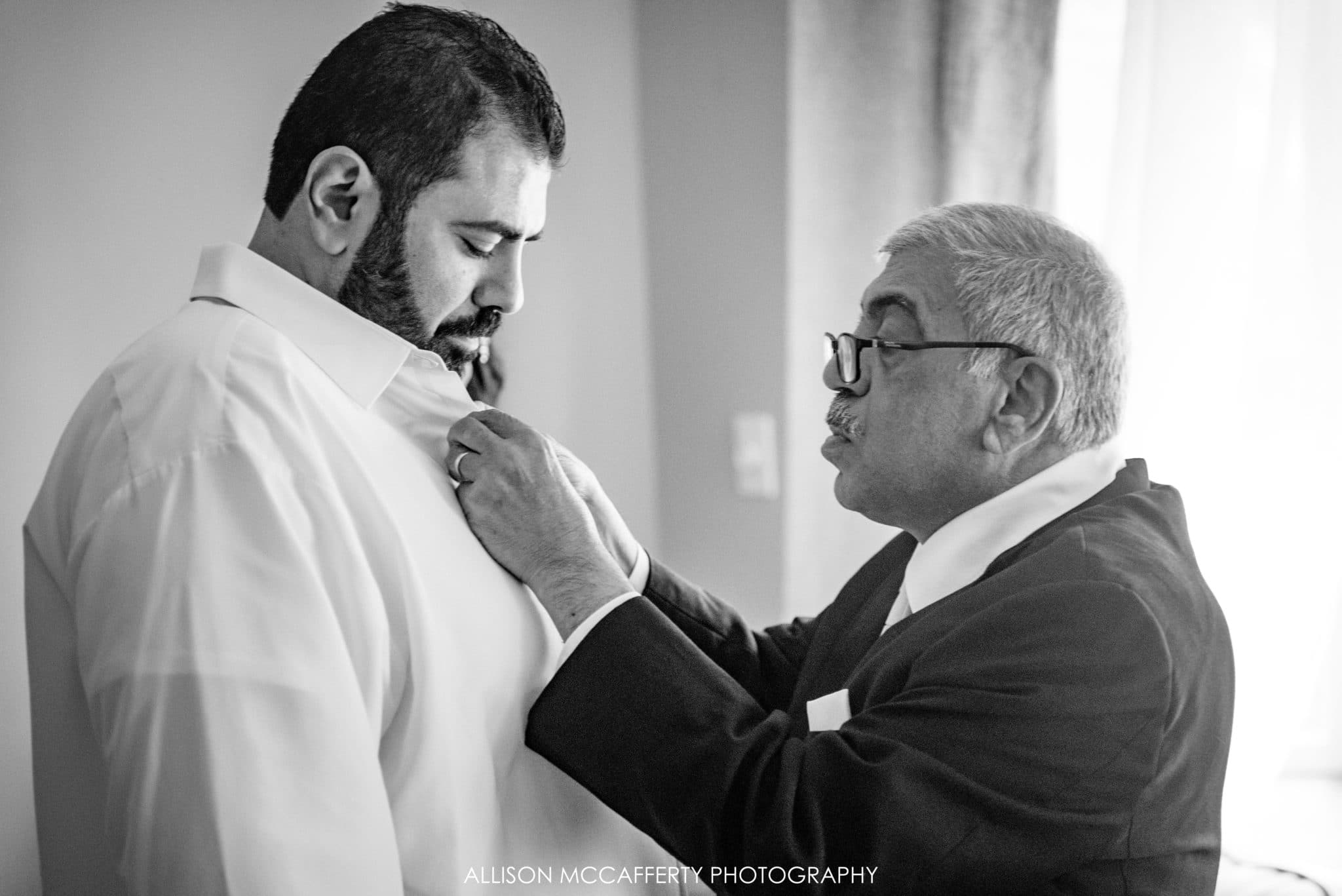 Father of the groom helping to dress his son