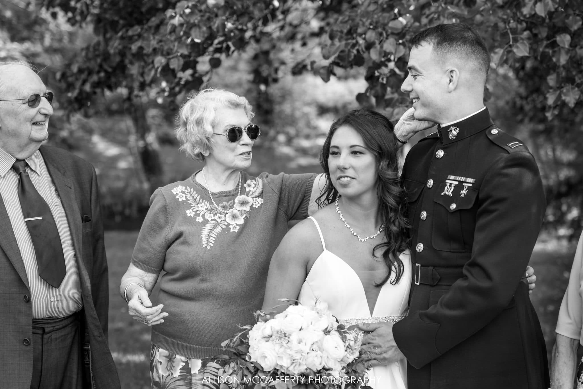 Grandmother touching grandson's face at his wedding