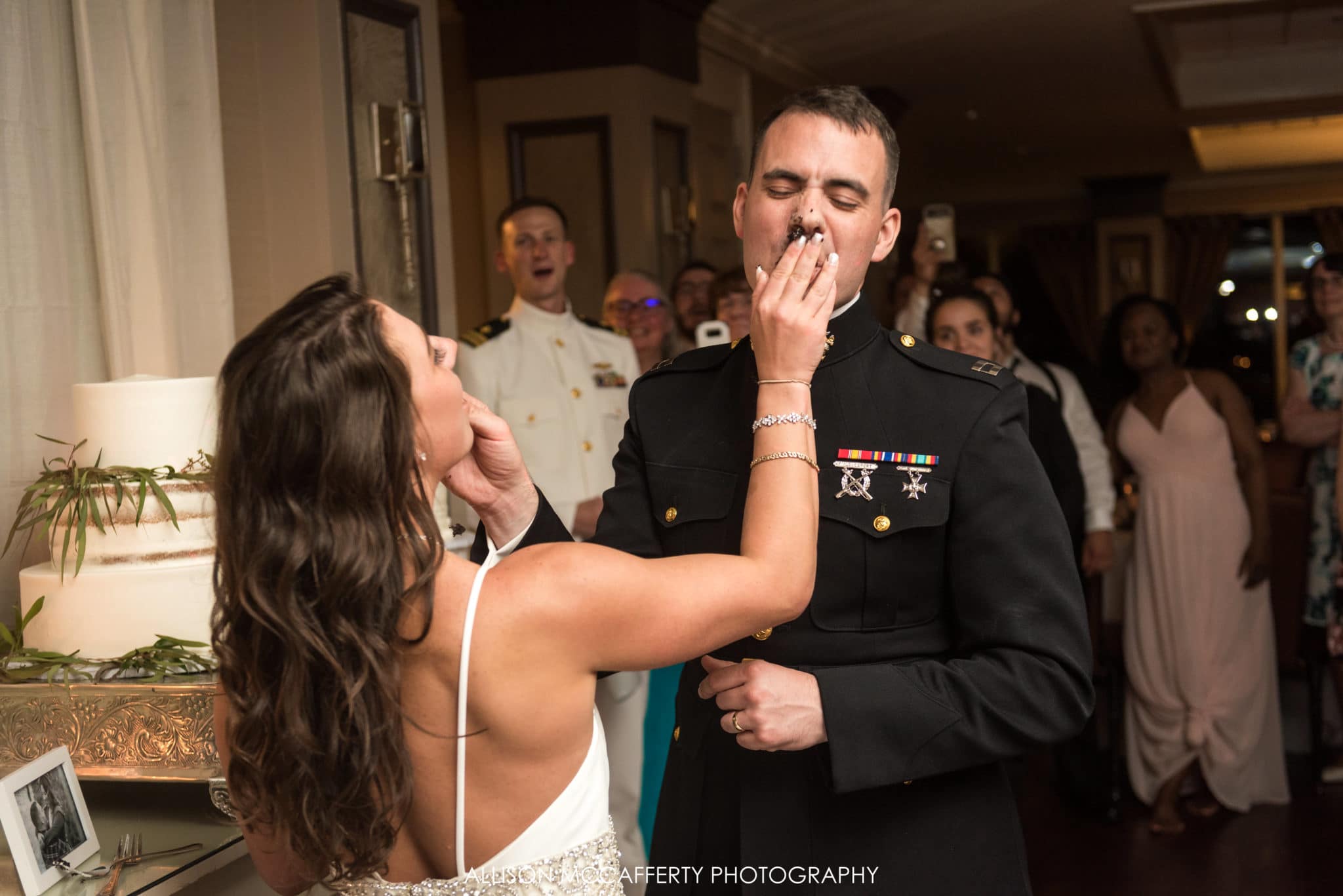 cake smash in grooms face at wedding