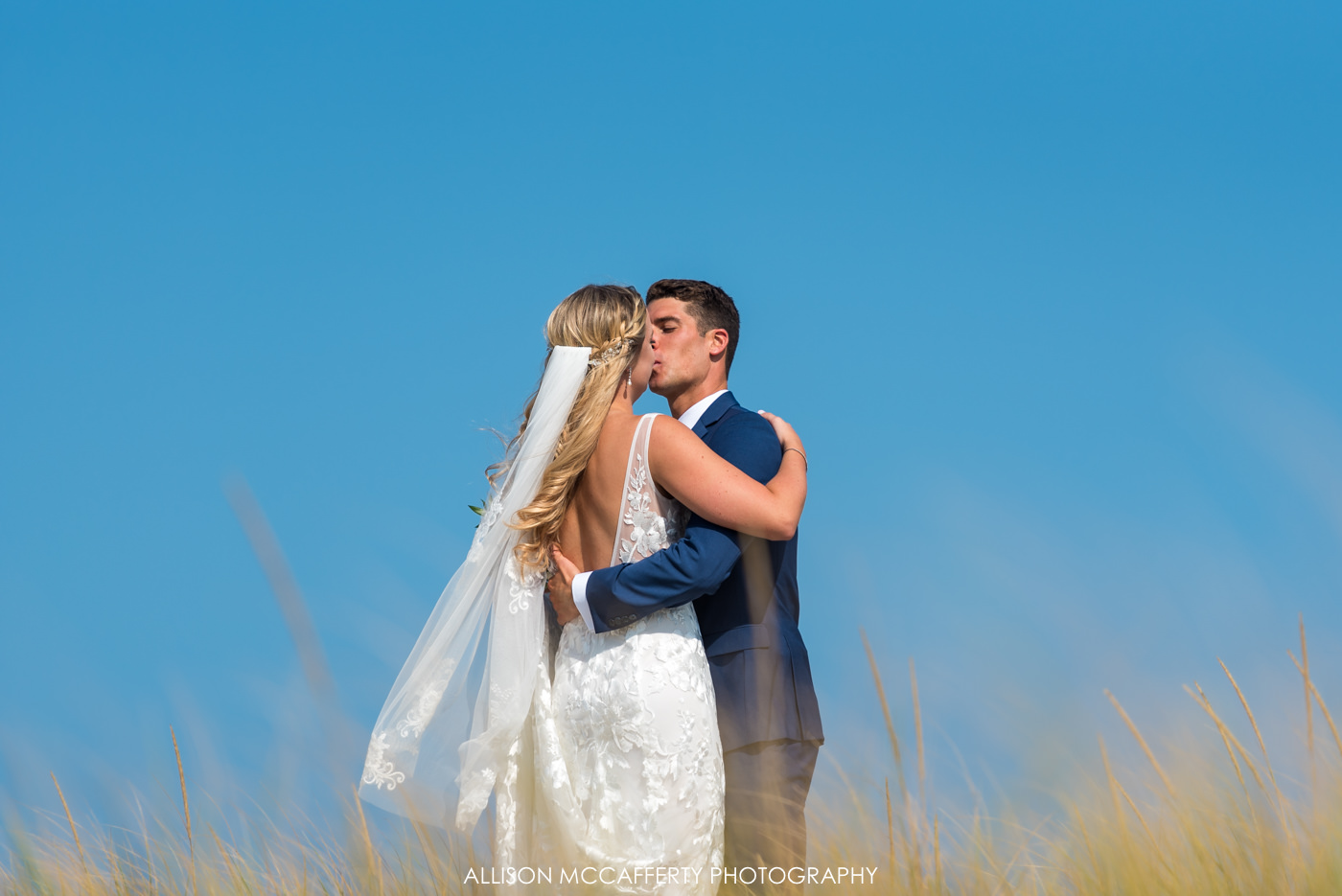 Bride and groom kissing on the dunes of LBI