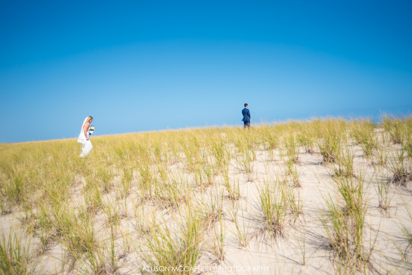 Bride walking to her groom across the dune in Long Beach Island