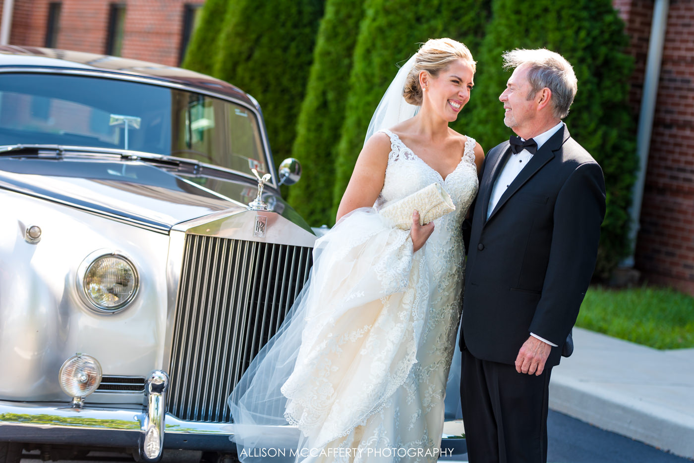 Bride and Father standing in front of a Rolls Royce on wedding day
