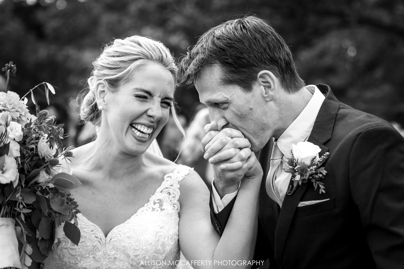 black and white photo of husband kissing his wife's hand