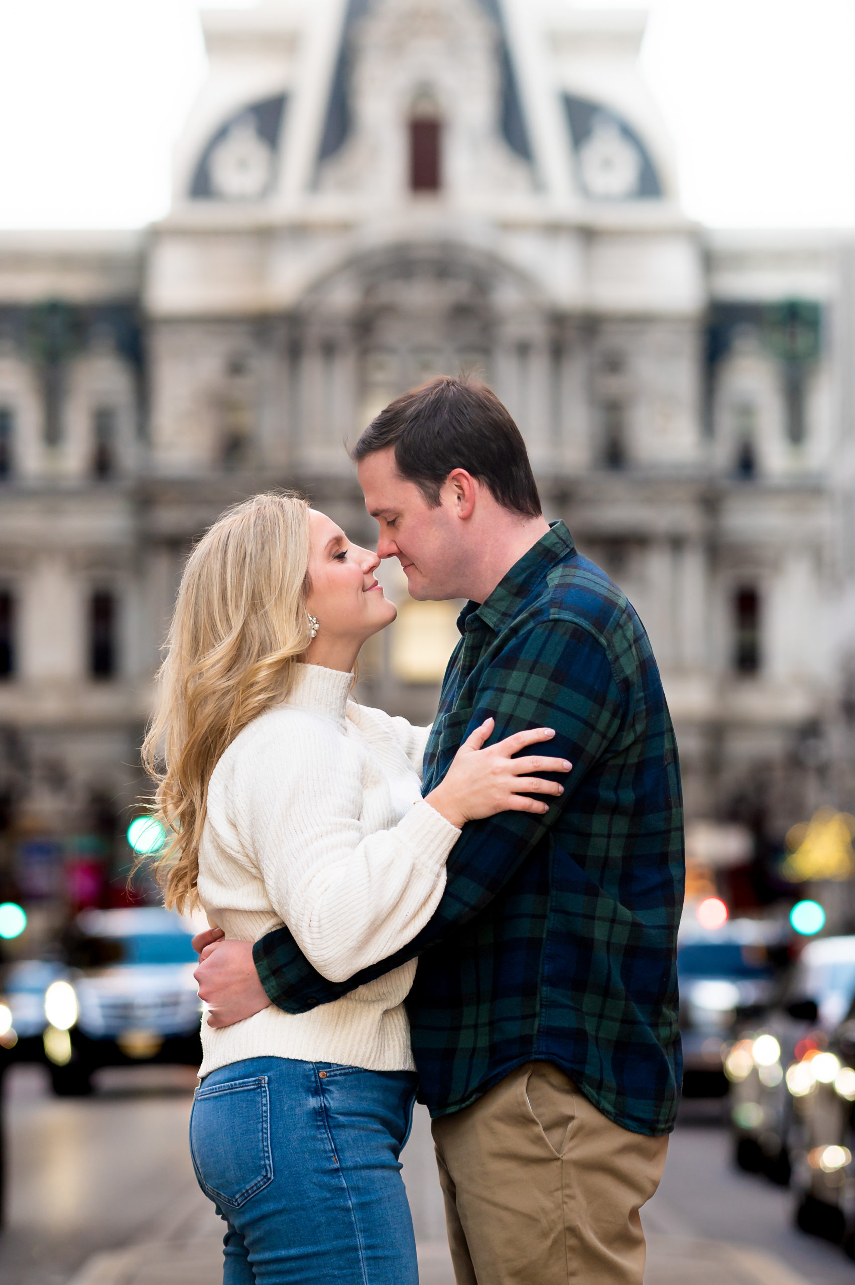 Engagement photo of a couple standing in front of City Hall on Broad Street in Philadelphia PA