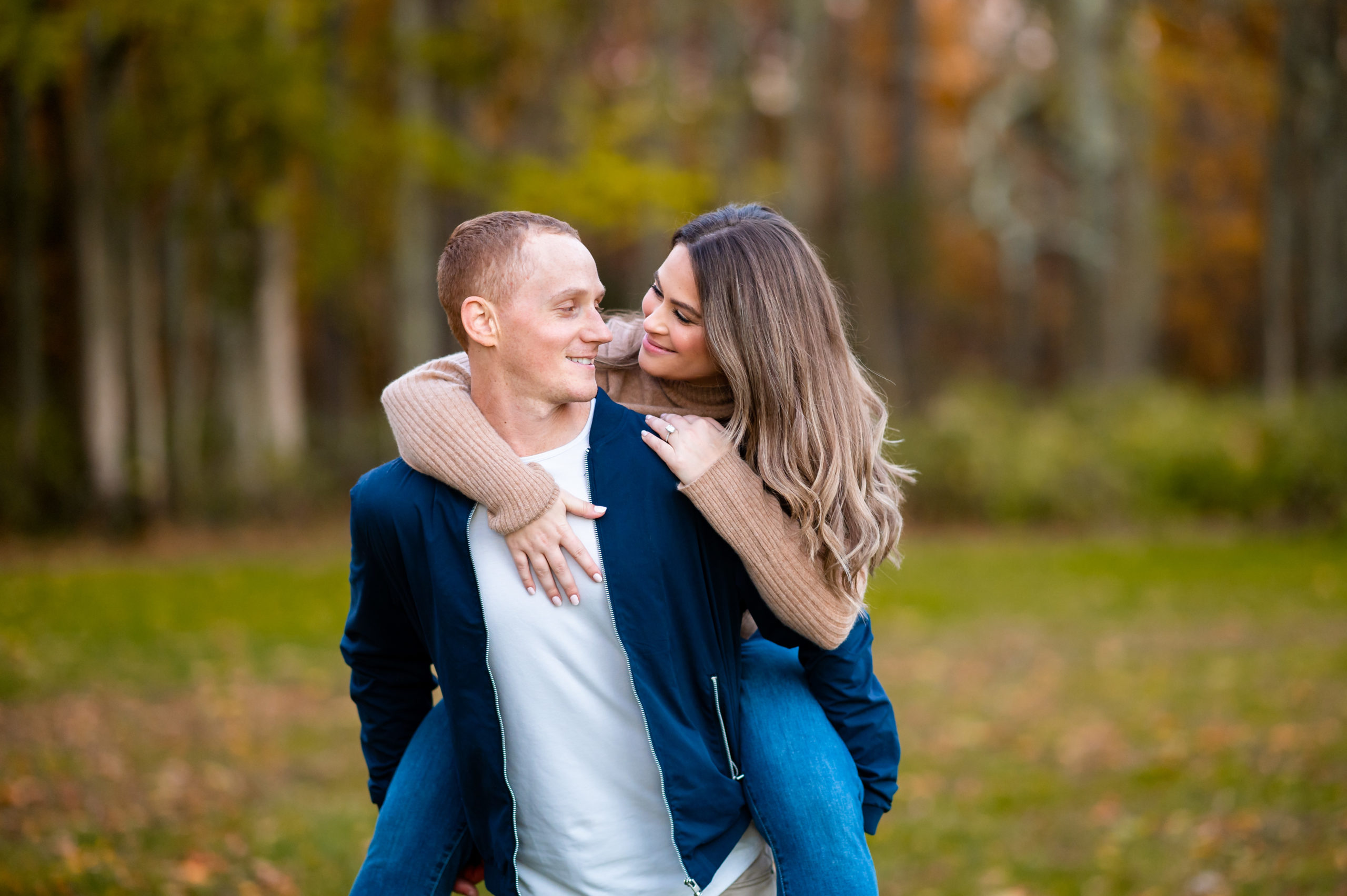 Engagement photo of a woman piggybacking on her fiancee in Central NJ