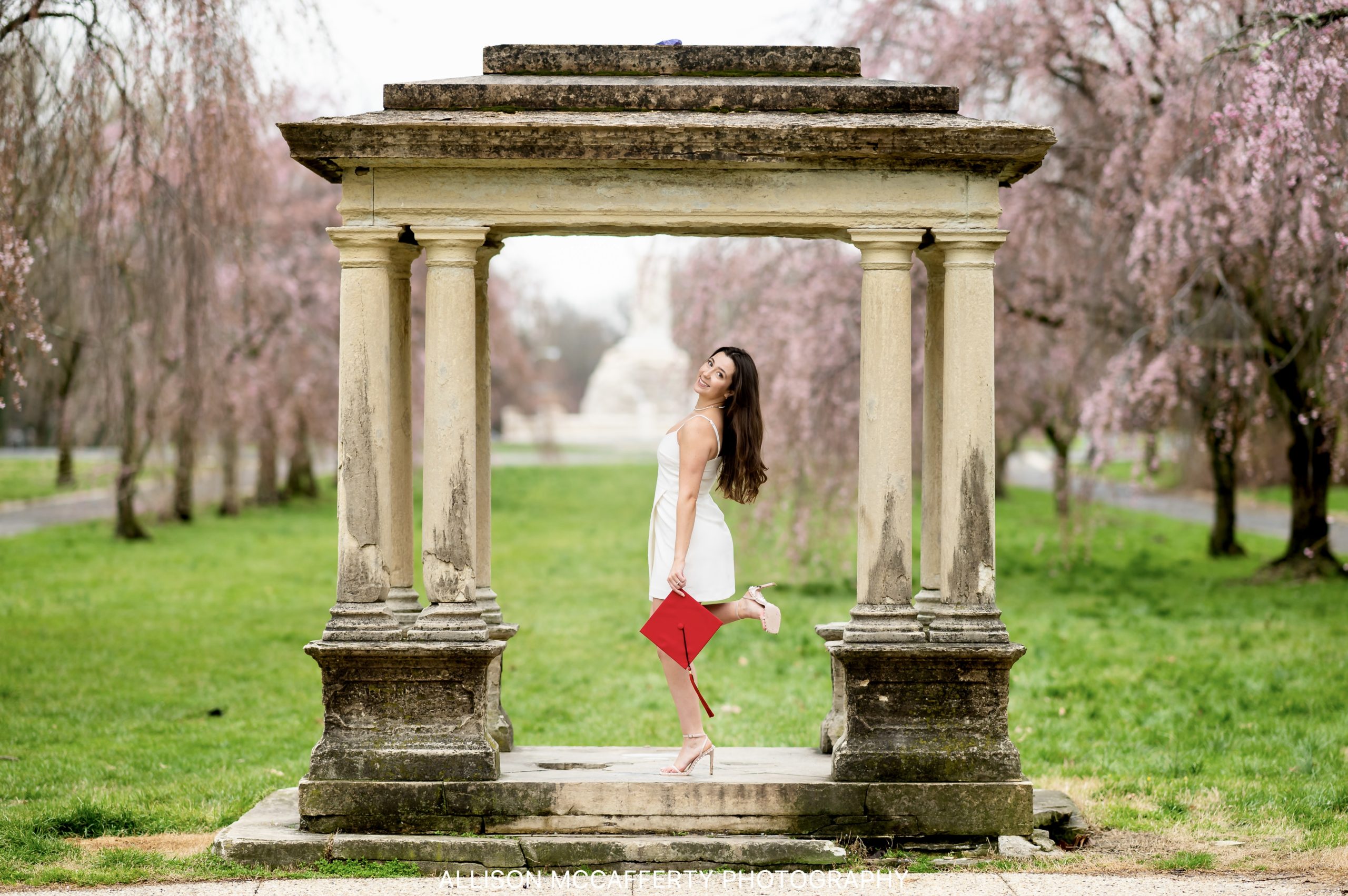 College graduation photo of a girl surrounded by cherry blossoms in Philadelphia PA