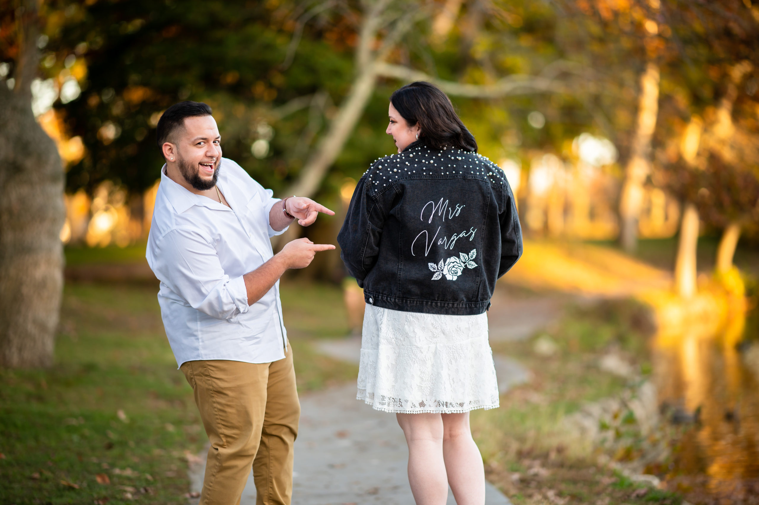 Spring Lake engagement session with the bride wearing a jean jacket with her new last name on it.