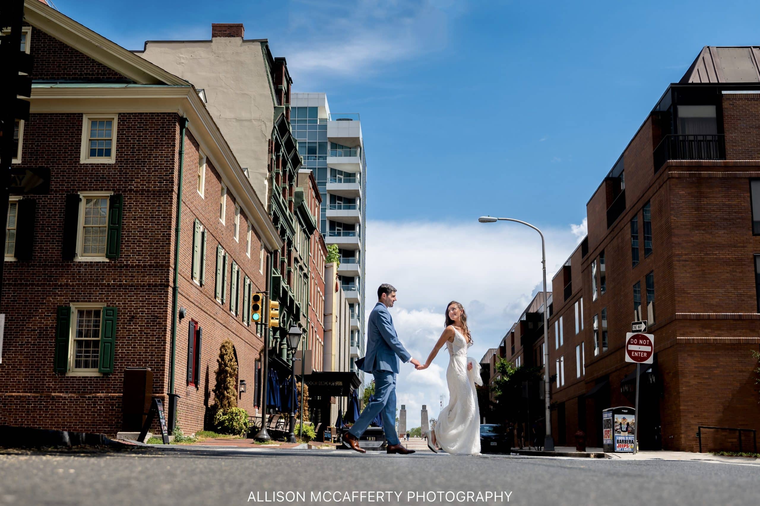 Photo of a woman leading her husband down the street on their wedding day in Philadelphia PA