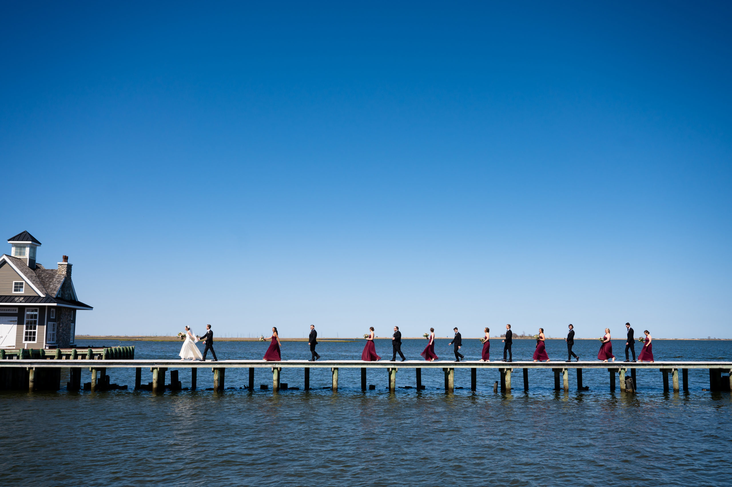 A photo of bridal party walking along the dock at Mallard Island Yacht club