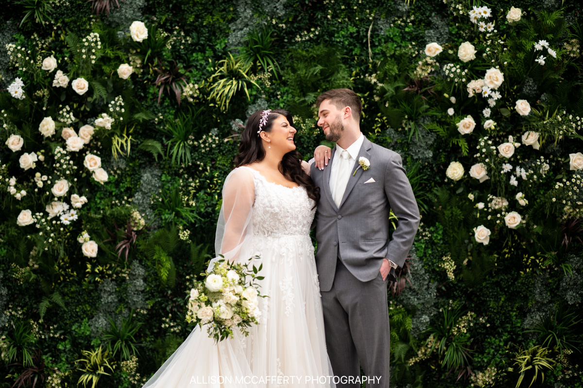 bride and groom standing in front of an ivy wall in The Refinery at Perona Farms Wedding