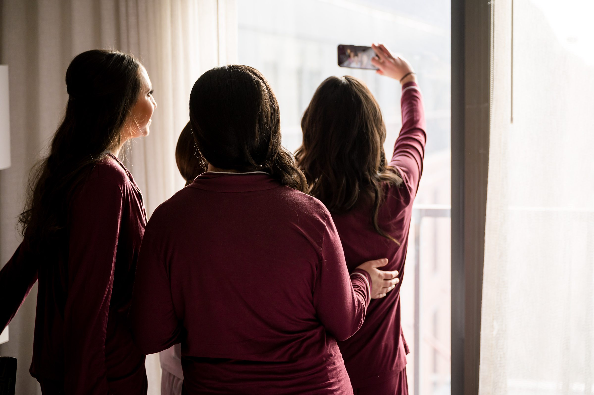 Four bridesmaids taking a selfie in their pajamas at a Lilah Events wedding.