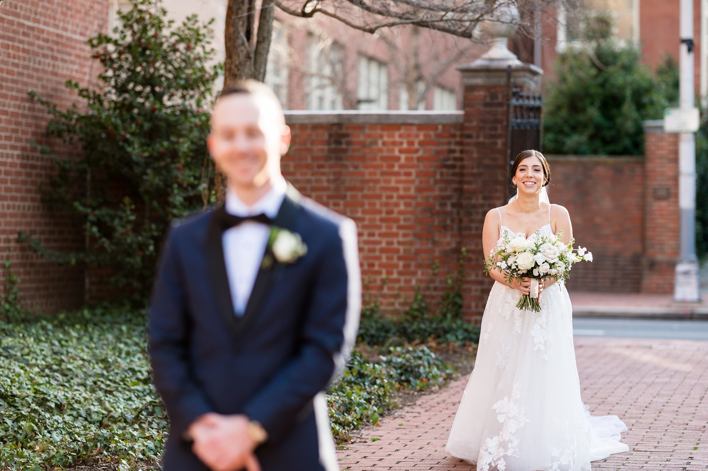 A bride and groom stood in front of a brick building, captured by Lilah Events at their wedding.