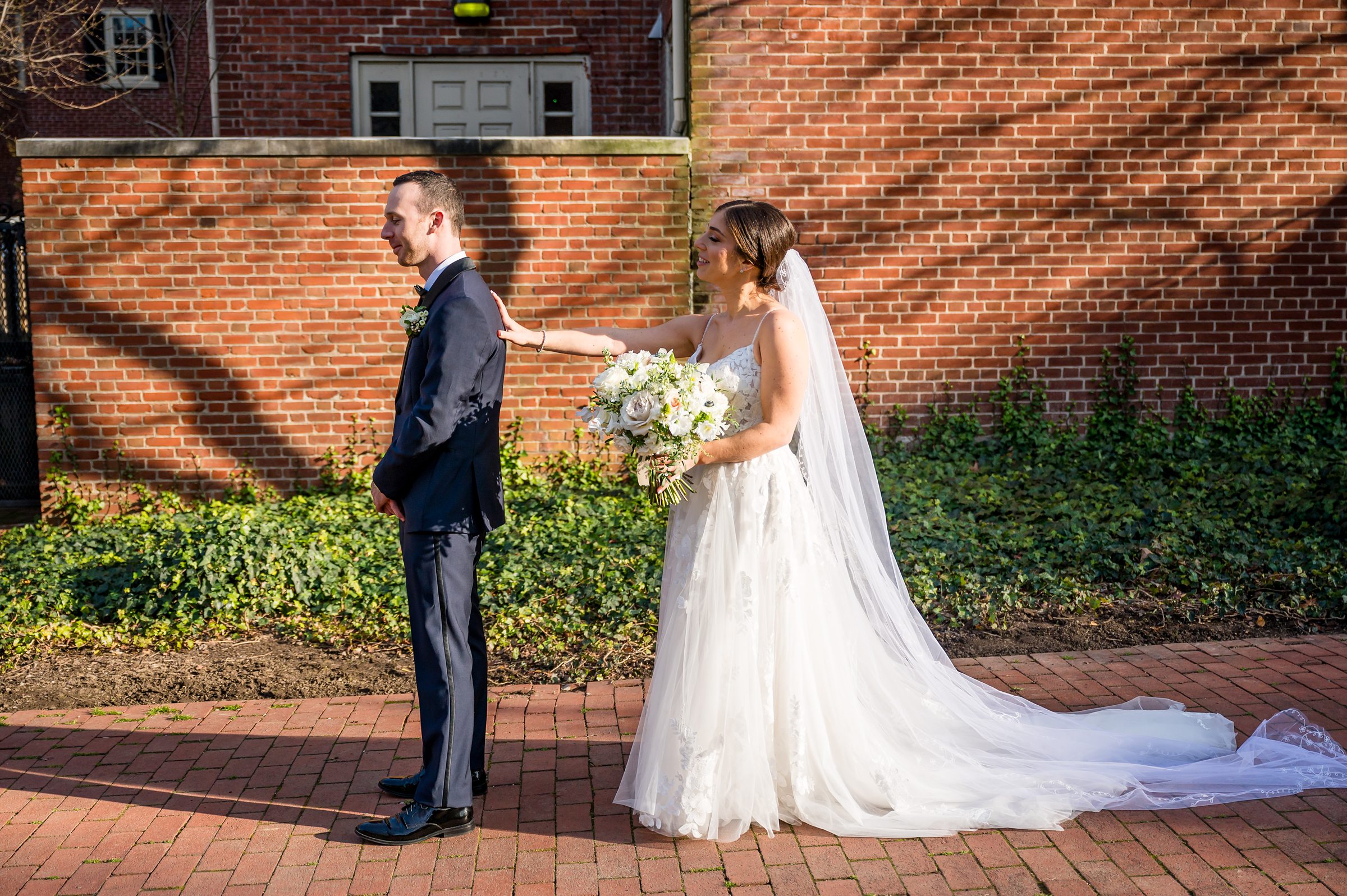 A bride and groom standing in front of a brick building at their Lilah Events wedding.