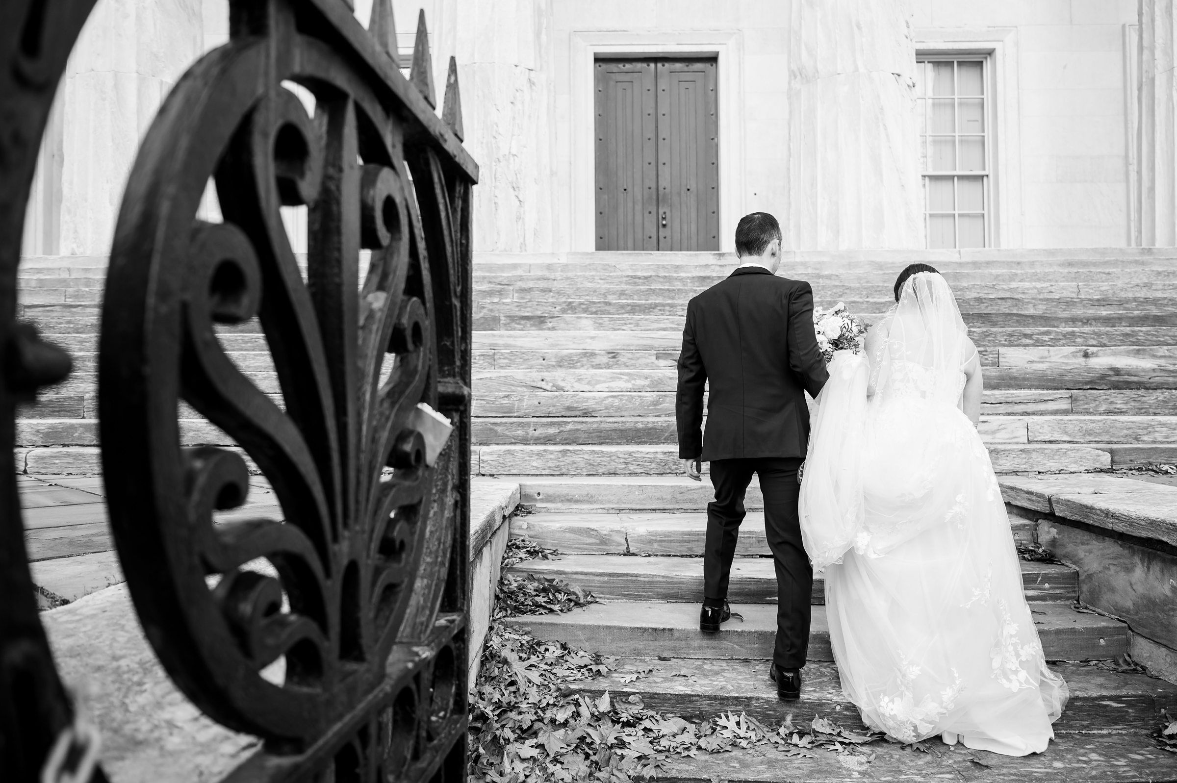 At a Lilah Events wedding, the bride and groom gracefully descend the steps of a building.