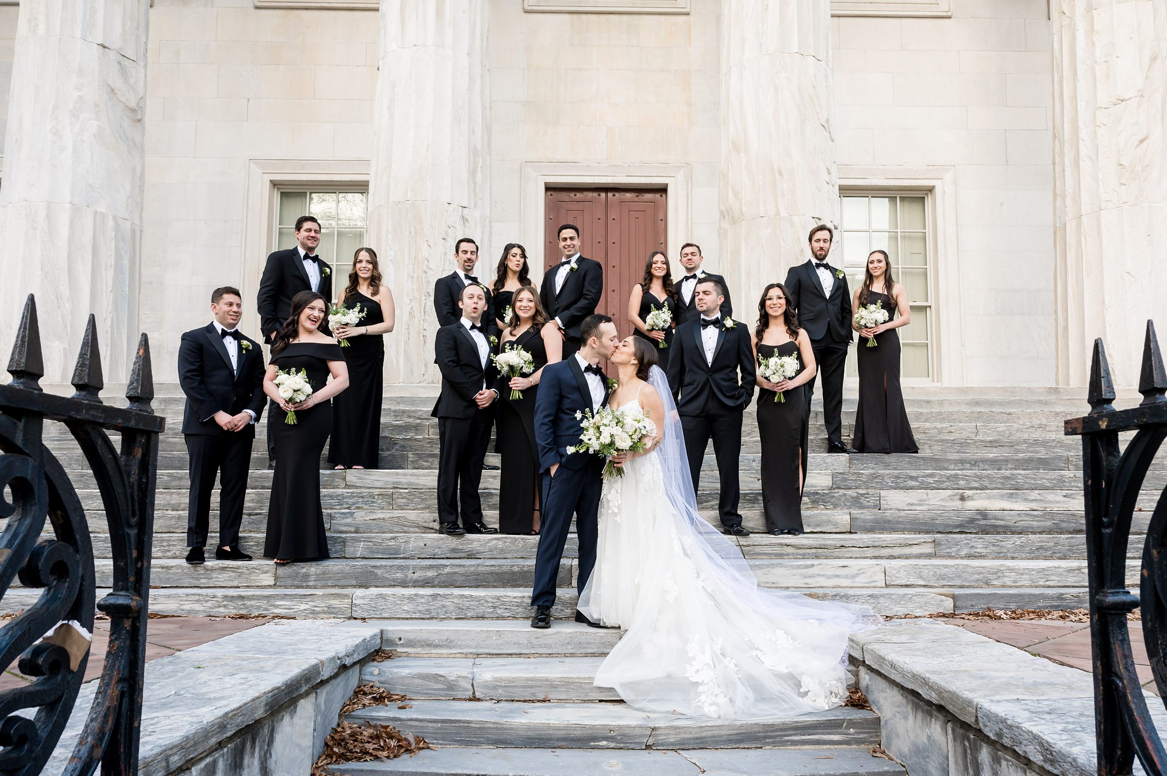 A Wedding party from Lilah Events posing on the steps of a building.