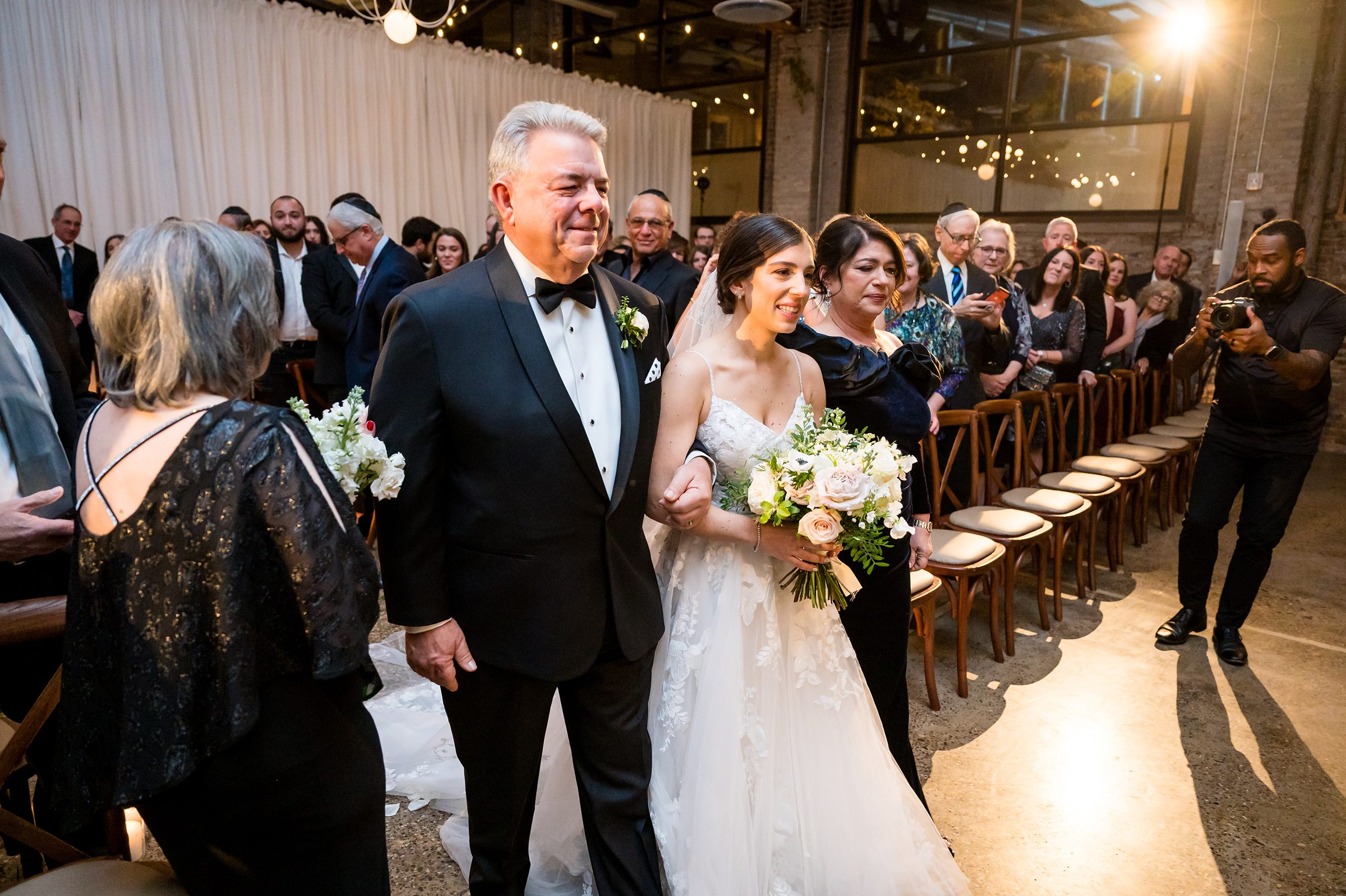 At a Lilah Events wedding, a bride gracefully walks down the aisle with her father.