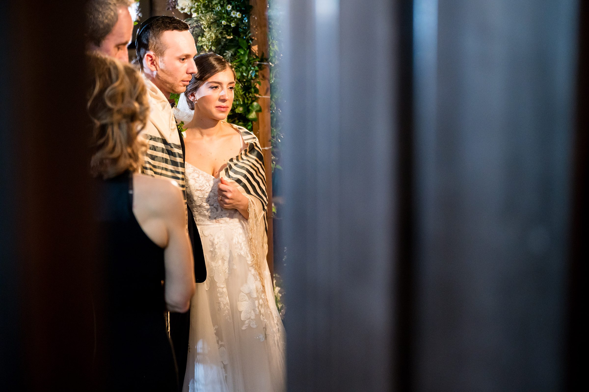 A bride and groom gazing at each other lovingly through a glass door at their Lilah Events wedding.