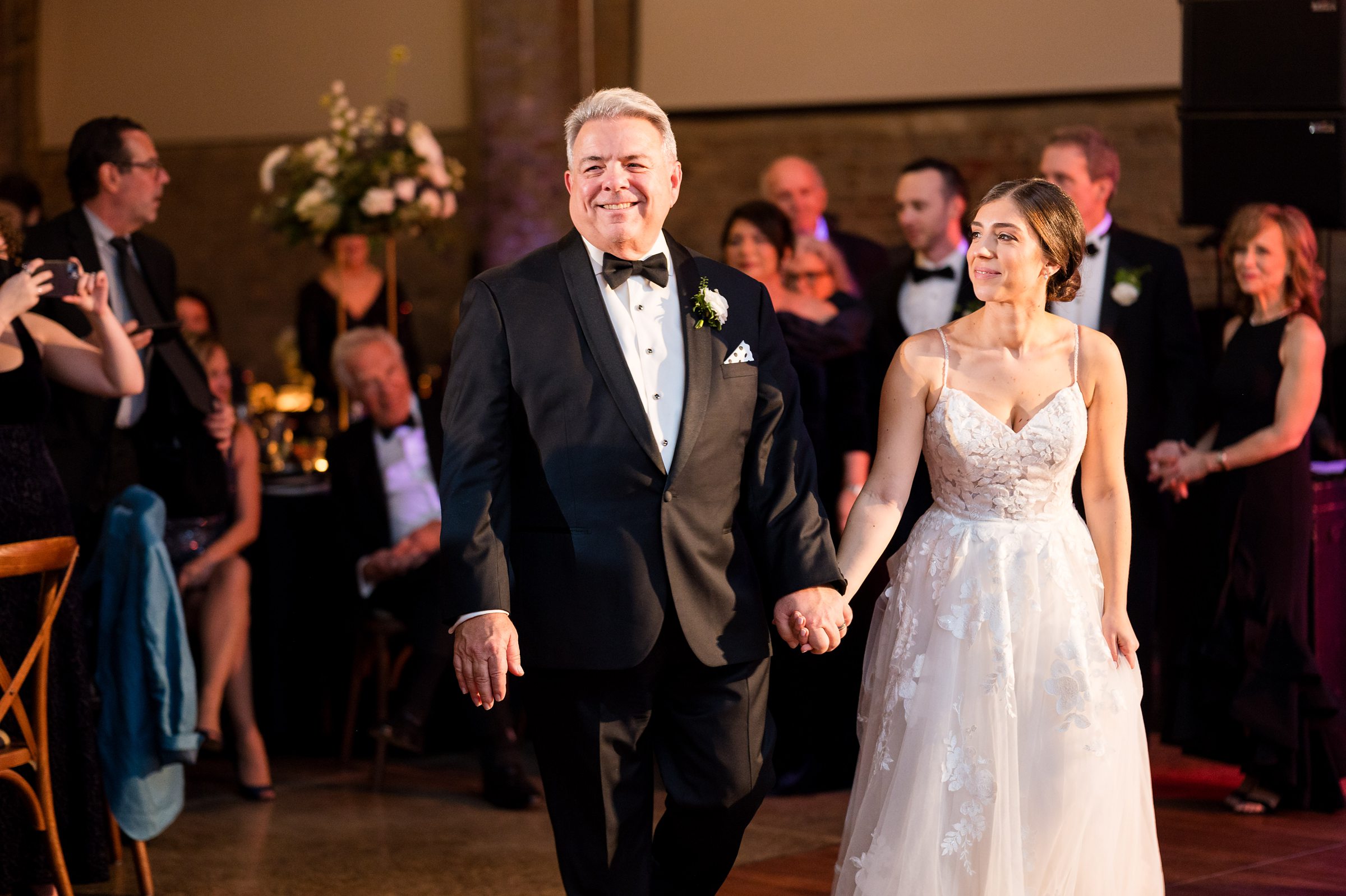 At a Lilah Events wedding, the bride and her father gracefully walk down the aisle at the reception.