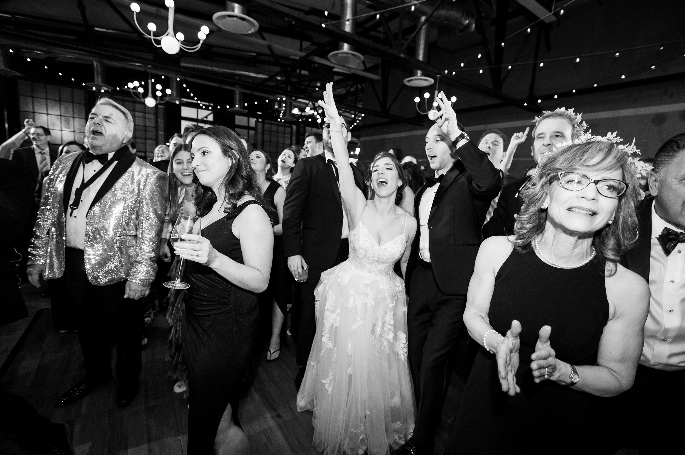 A black and white photo of people dancing at a Lilah Events wedding.