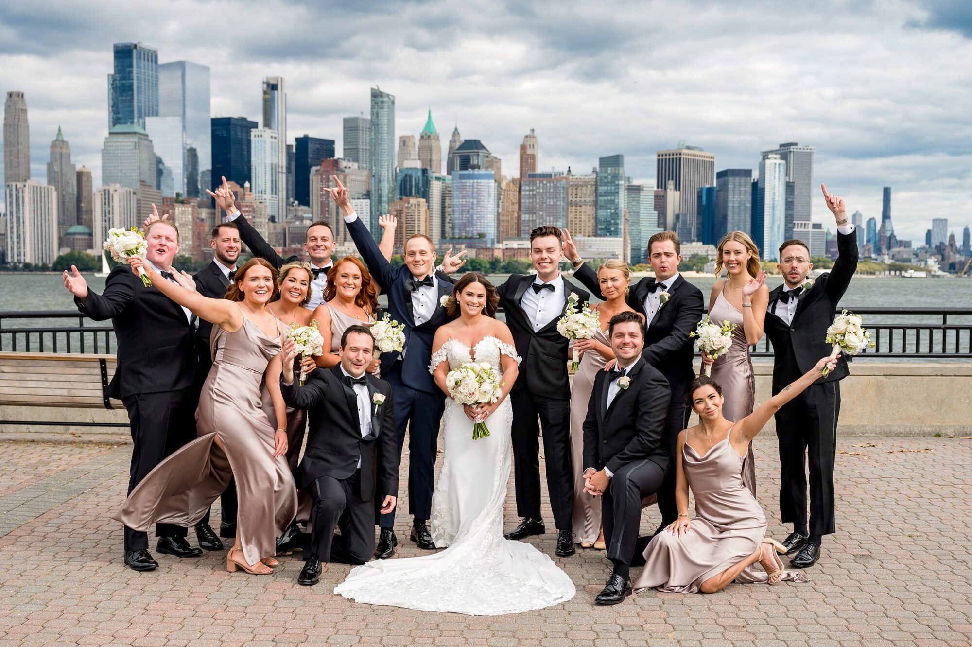 A wedding party poses in front of the manhattan skyline.