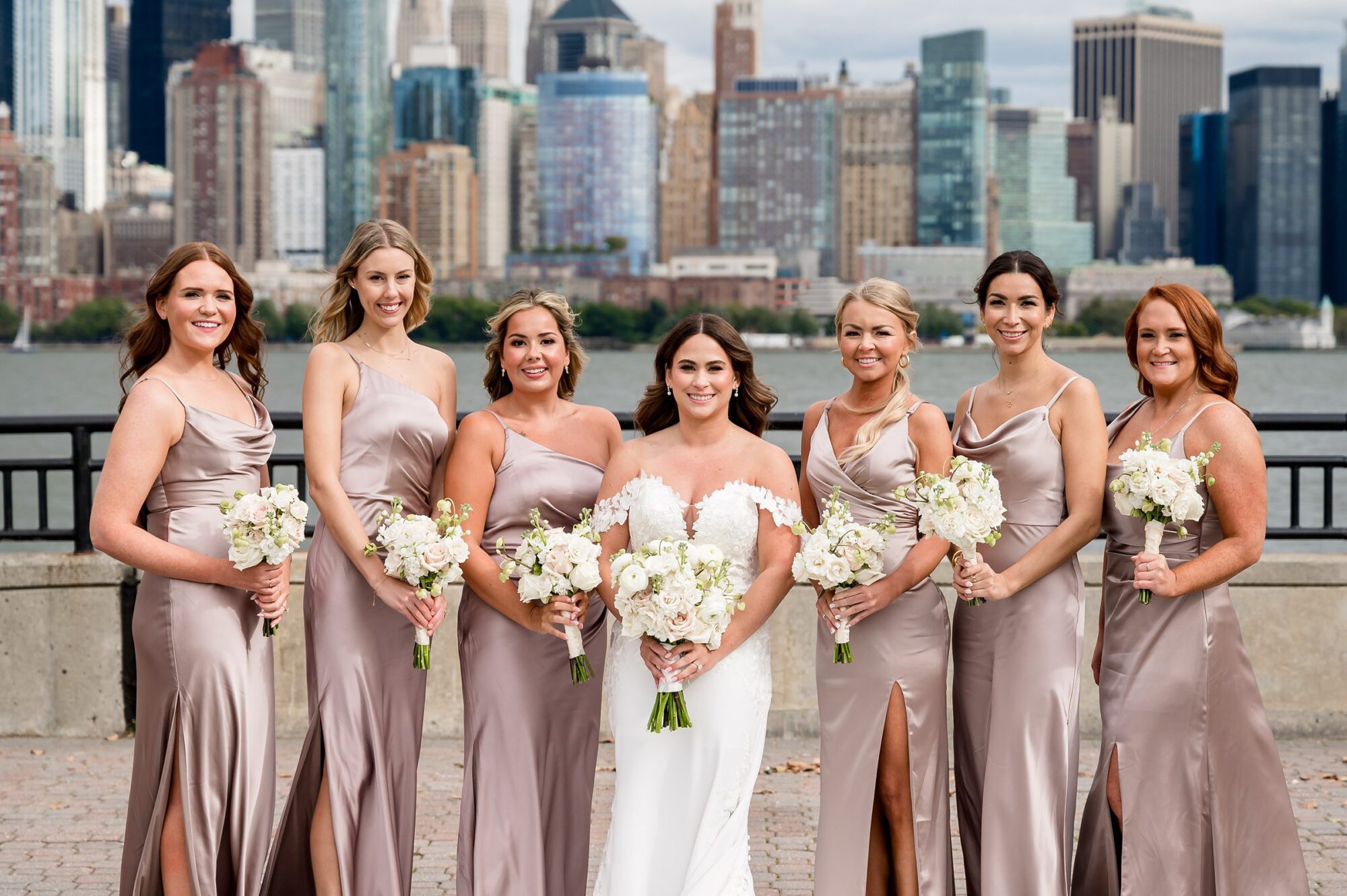 Bridesmaids pose in front of the manhattan skyline.