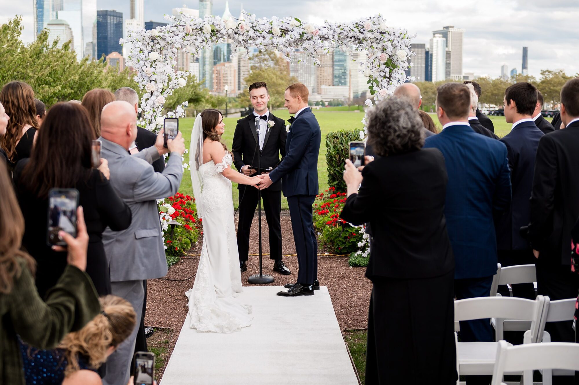 A bride and groom exchange vows in front of a city skyline.