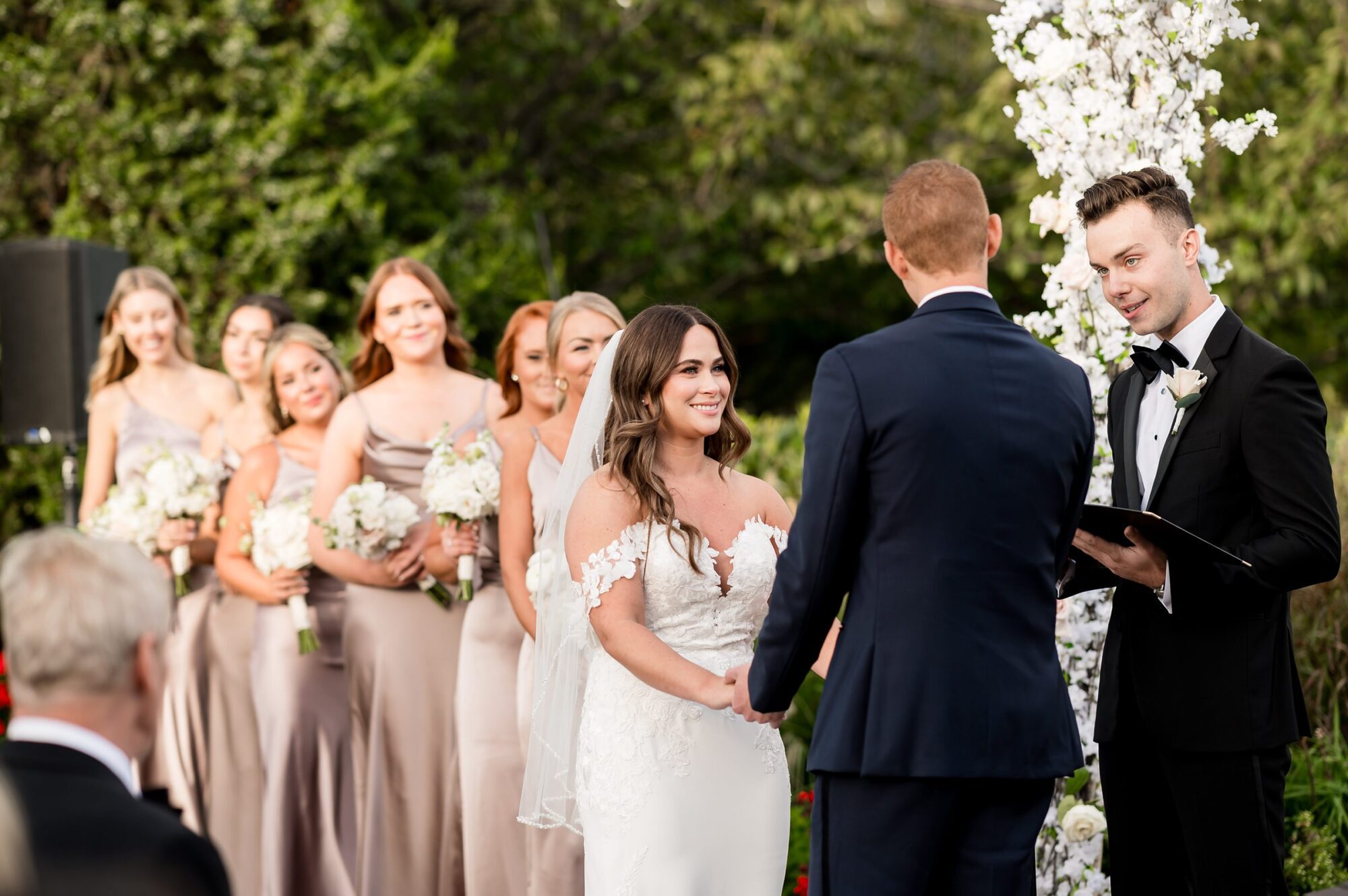 A bride and groom exchange vows during their outdoor wedding ceremony.