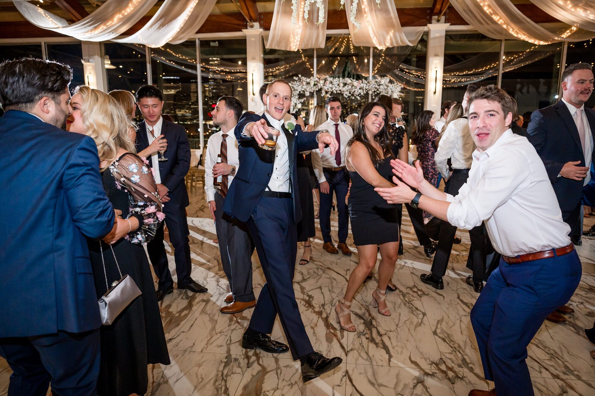 A group of people dancing at a wedding reception.