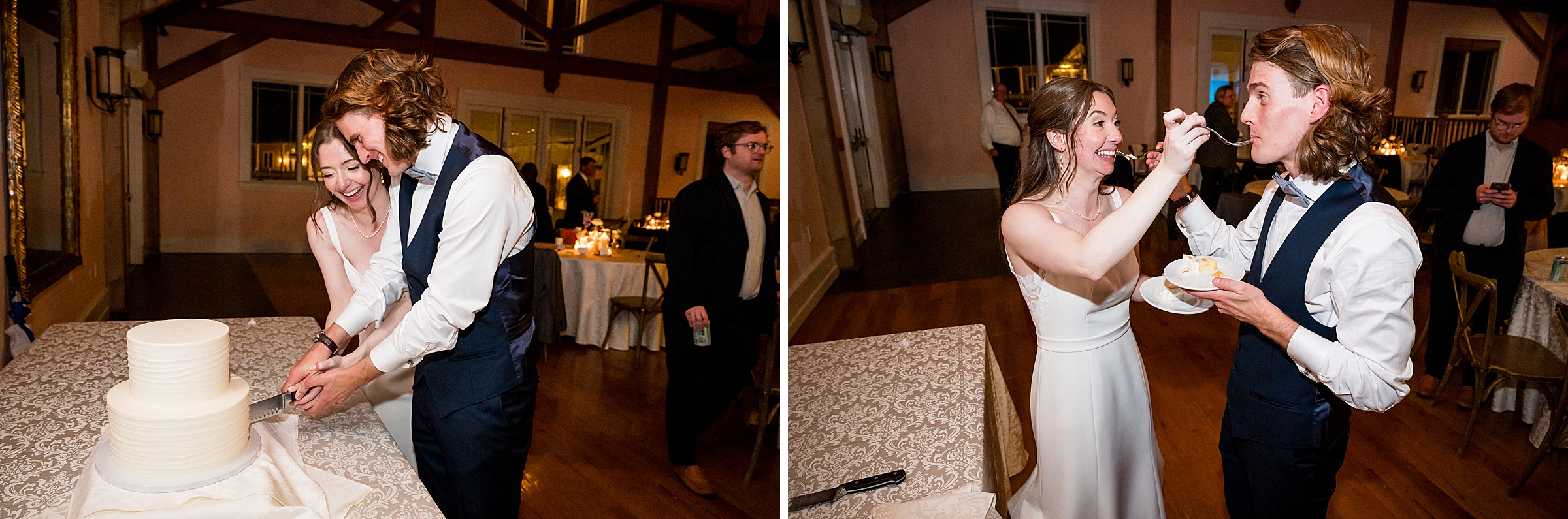 A couple is cutting their wedding cake and feeding each other a piece in a warmly lit room.